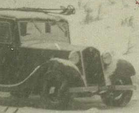 Car parked in the snow with skis on the roof