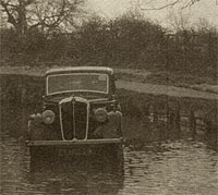 A classic Morris car parked in a river