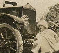 A child tries the vintage car's starting handle