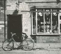 A bicycle left outside a shop