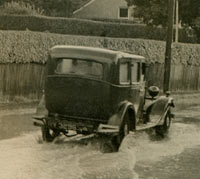 A car drives along a flooded street