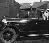 A Morris parked outside an old garage