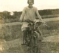 A lady sat on her vintage motorcycle