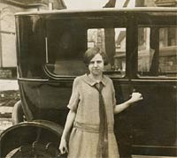 A girl stood with a 1920s car