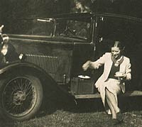 Lady drinks a cup of tea with her 1930s Rover car