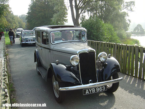 A 1930s Minx and a later Sunbeam Rapier cross the bridge into a showground.