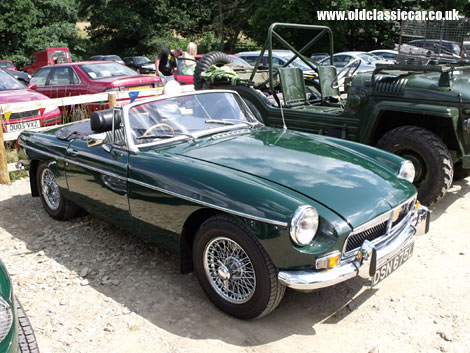 An MGB Roadster soaks up the sun, alongside an Austin Champ.